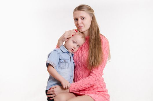 Young beautiful girl sitting on a chair with a three year old son