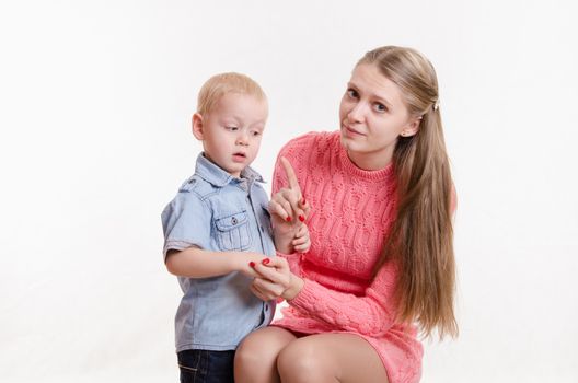 Young beautiful mother scolds her rebellious and moody three year old boy