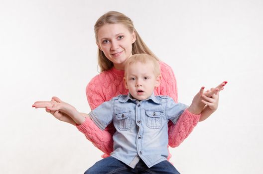 Young beautiful girl sitting on a chair with a three year old son