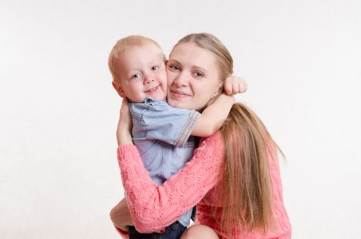 On the lap of a young beautiful girl sits her three year old son