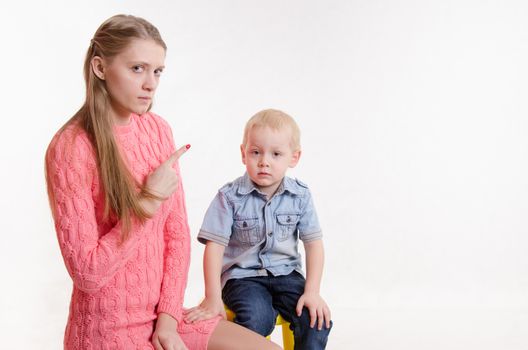 Young beautiful mother scolds her rebellious and moody three year old boy