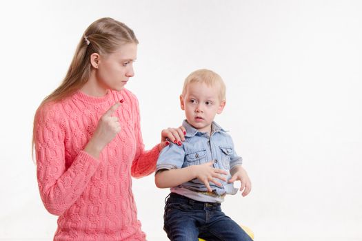 Young beautiful mother scolds her rebellious and moody three year old boy