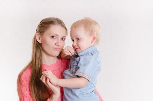 Young beautiful girl sitting on a chair with a three year old son