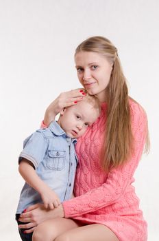 Young beautiful girl sitting on a chair with a three year old son