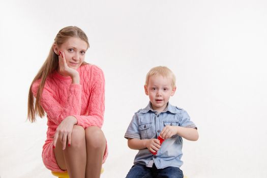 Young beautiful girl blow bubbles with a three year old son