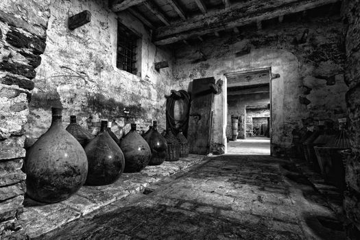 Old carboys in a very old house without doors.