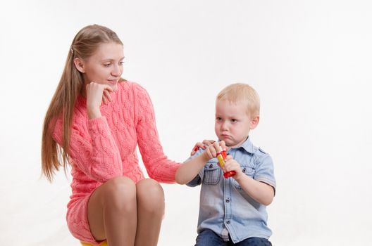 Young beautiful girl blow bubbles with a three year old son