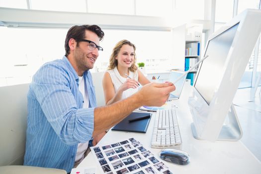 Photo editors working together on graphics tablet in office