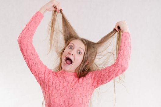 Portrait of a young emotional beautiful girl of the European appearance on a white background