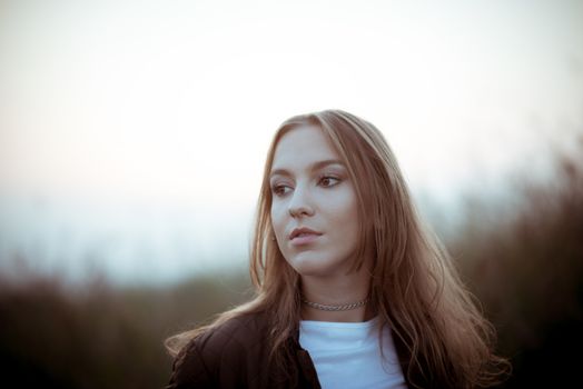 Brunette girl in late autumn daydreaming outdoors