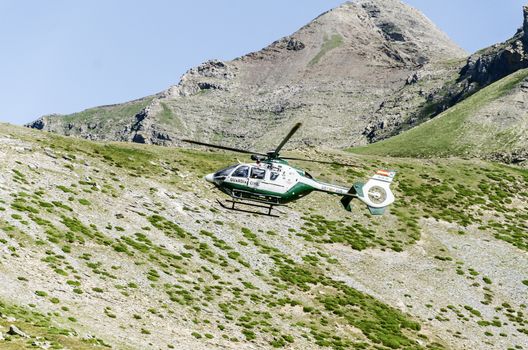 Chopper of Guardia civil patrulling over the mountain in Spain