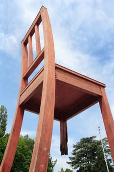 Photo of the Broken Chair wooden sculpture in Geneva Switzerland. Giant chair with a broken leg standing across the street from the Palace of Nations. It symbolizes an opposition to land mines. Photo taken June 9, 2010.
