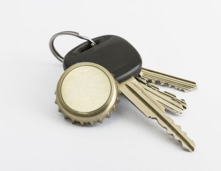 car key and bottle cap in close up with neutral grey background