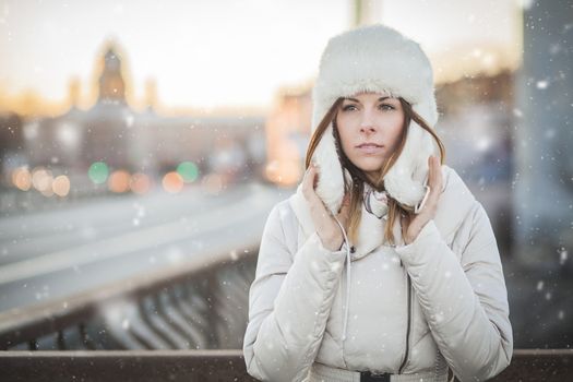 Brunette girl in cold weather with falling snow in russia