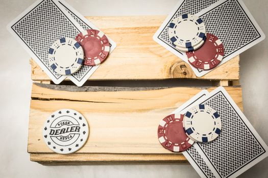 Playing cards lying on a wooden support together with dealer and blind buttons