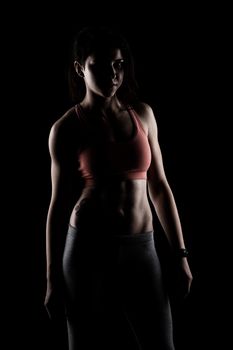 fitness girl posing against dark background