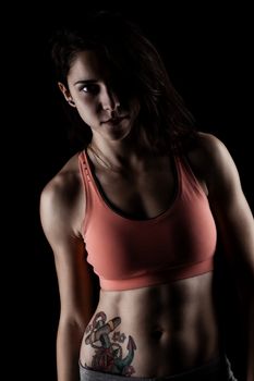 fitness girl posing against dark background