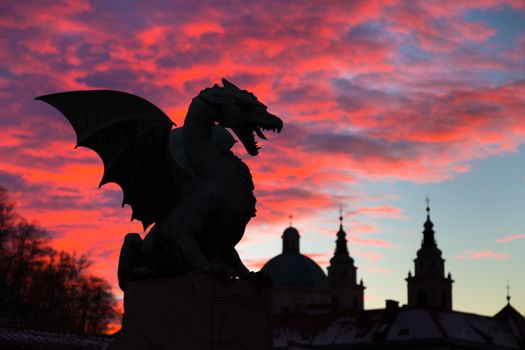 Vivid sunset sky over silhouette of Famous Dragon bridge, symbol of Ljubljana, capital of Slovenia, Europe.