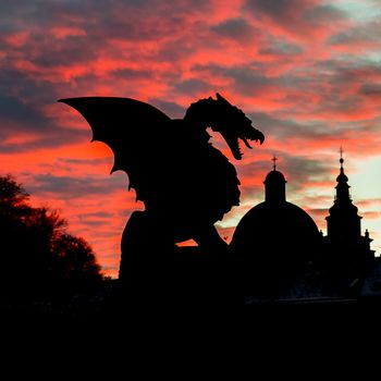Vivid sunset sky over silhouette of Famous Dragon bridge, symbol of Ljubljana, capital of Slovenia, Europe.