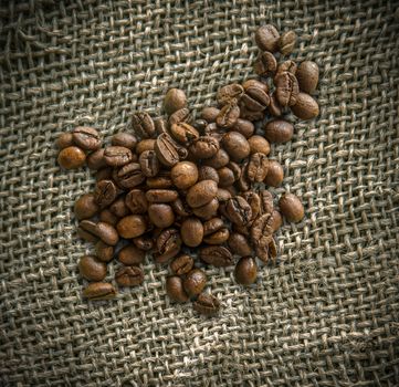 Organic Fair Trade Coffee Beans On Top Of A Rustic Woven Burlap Bag