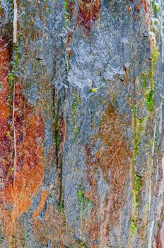 Background of a rough rock wall with brown discoloration.