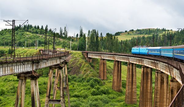 Passenger train going across the bridge in the Carpathian Mountains