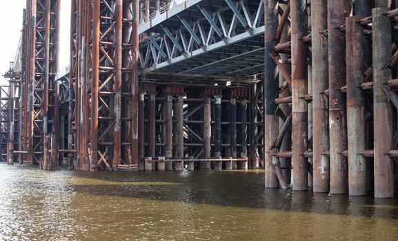 Bridge construction. Rusty metal piers of the unfinished bridge across the Dnieper in Kyiv (Ukraine).