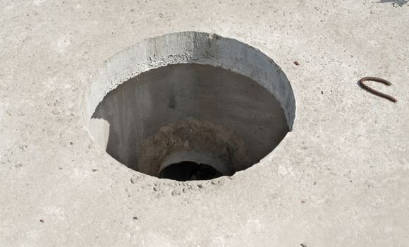 Manhole without cover in new concrete block.