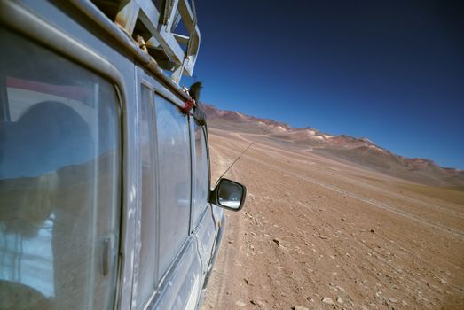 Offroad vehicle crossing bolivian desert near Salar de Uyuni