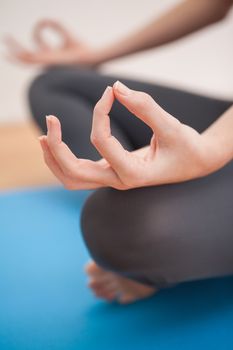 Fit woman doing yoga at home on wooden floor