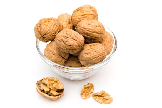 Bowl with unshelled walnuts on white background