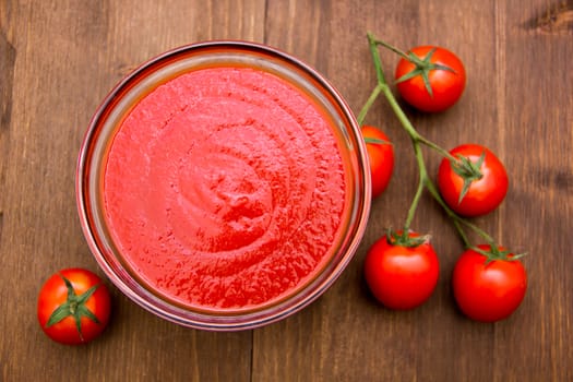 Tomato sauce on wooden table seen from above