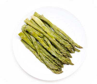 Cooked asparagus on plate on white background seen from above
