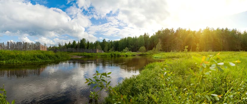 a small river that flows near the village, next to the field and forest