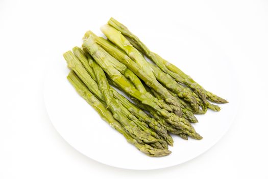 Cooked asparagus on plate on white background