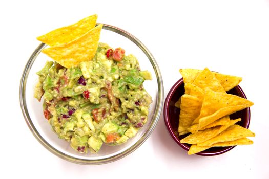 Guacamole and nachos on a white background seen from above