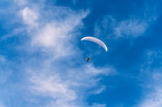 Powered paragliding flying against the blue sky