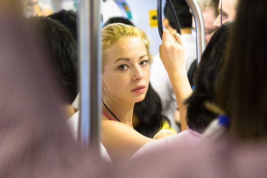 Blonde caucasian lady traveling by public transport.