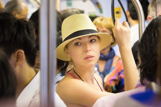 Blonde caucasian lady traveling by public transport.