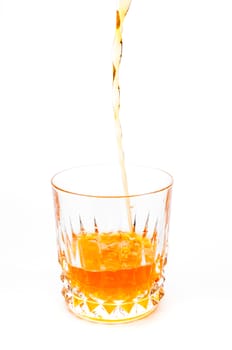 Pouring orange juice into the glass isolated on white