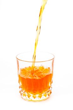 Pouring orange juice into the glass isolated on white