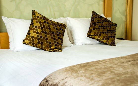 White and brown bed cover and pillow, bed and green wall