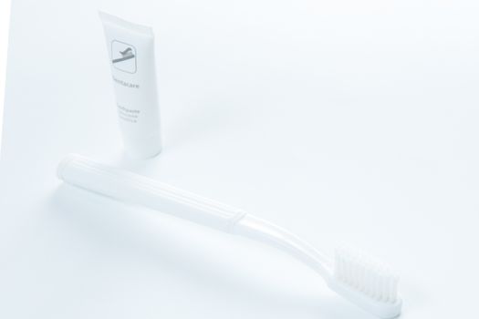 Toothpaste and toothbrush over white. Shallow DOF.