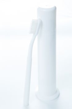 Toothpaste and toothbrush over white. Shallow DOF.