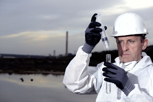 
Worker in a protective suit examining pollution in the water at the industry.