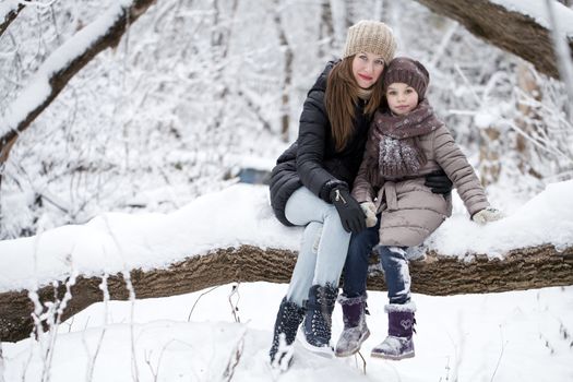 Portrait of a nine year girl with her mother in winter park