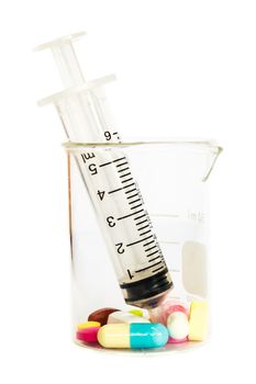 syringe in beaker and group of drugs on white background (isolated)