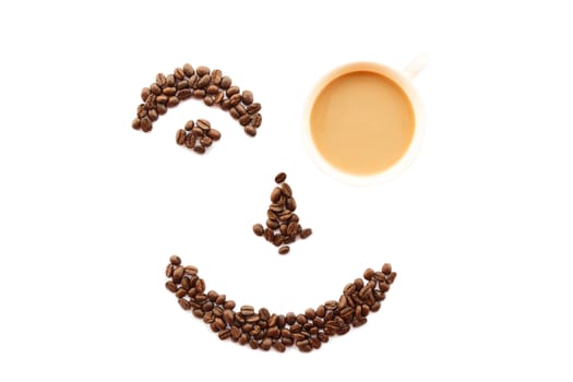 happy face shaped of coffee beans with cup on white background (isolated)