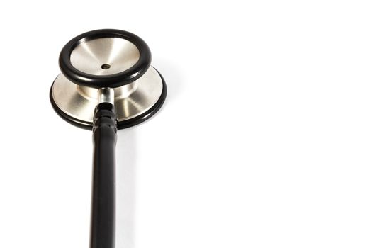 The head of black stethoscope at left side and blank area at right on white background