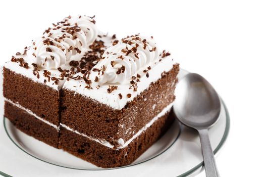 chocolate cakes with white cream on top and spoon on plate on white background(isolated) and blank area at right side